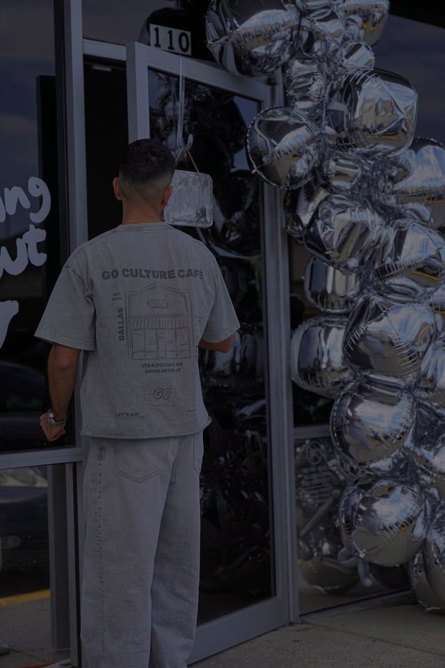 The Go Culture founders under the chrome wall logo