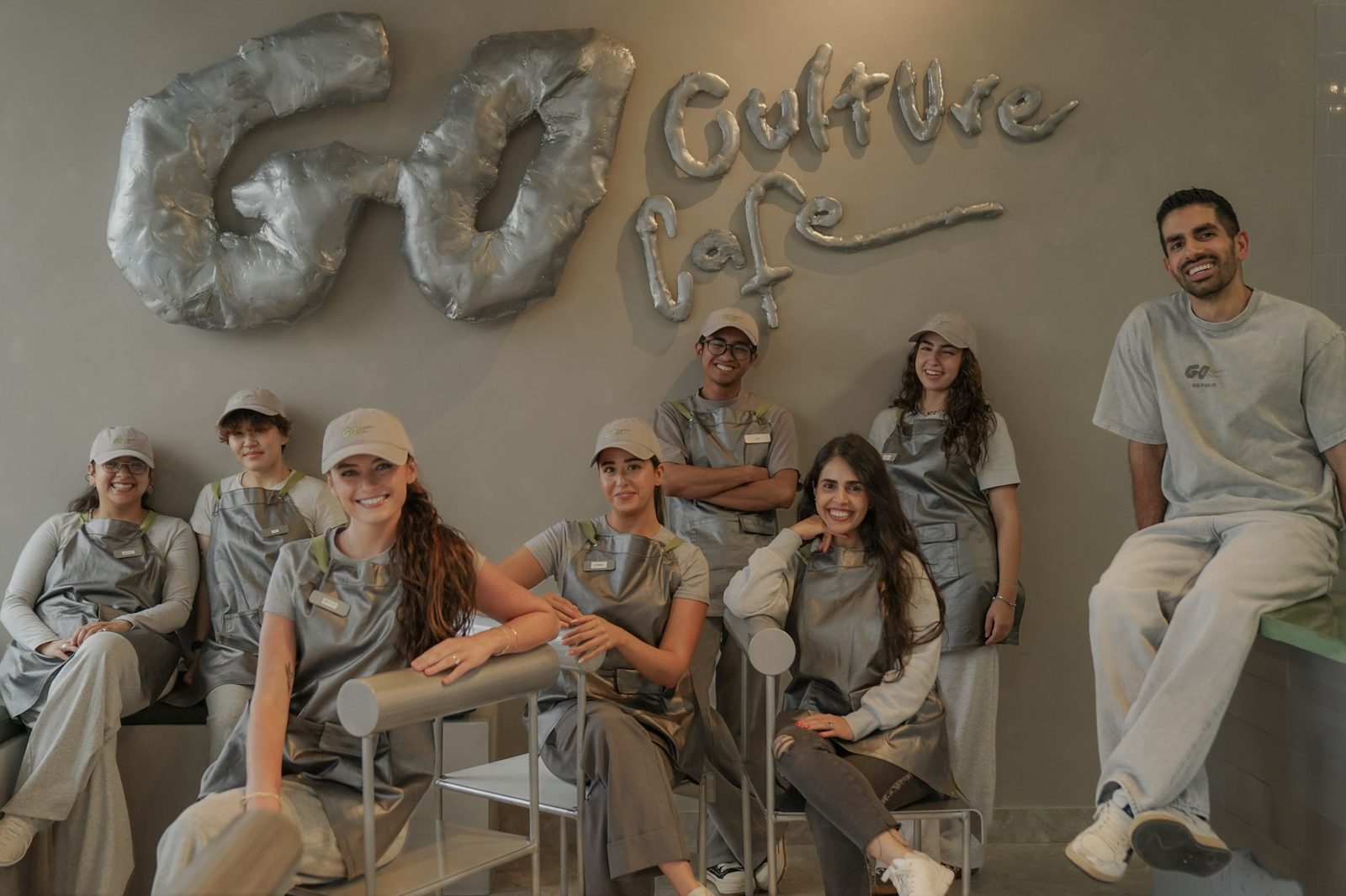 The Go Culture crew smiling under the chrome wall logo